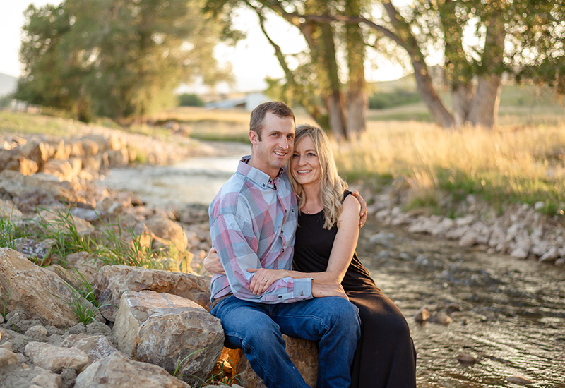 Couple sitting on rocks next to a river